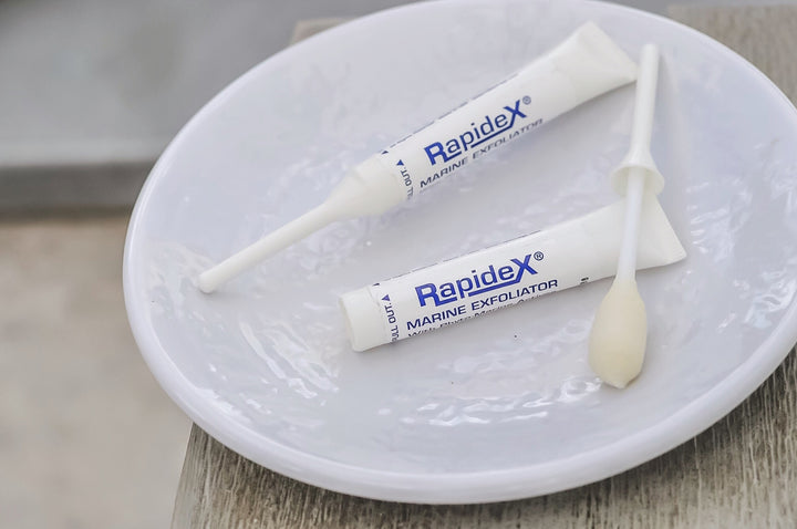 Two Rapidex Exfoliator tubes on a white plate. One tube is opened. 