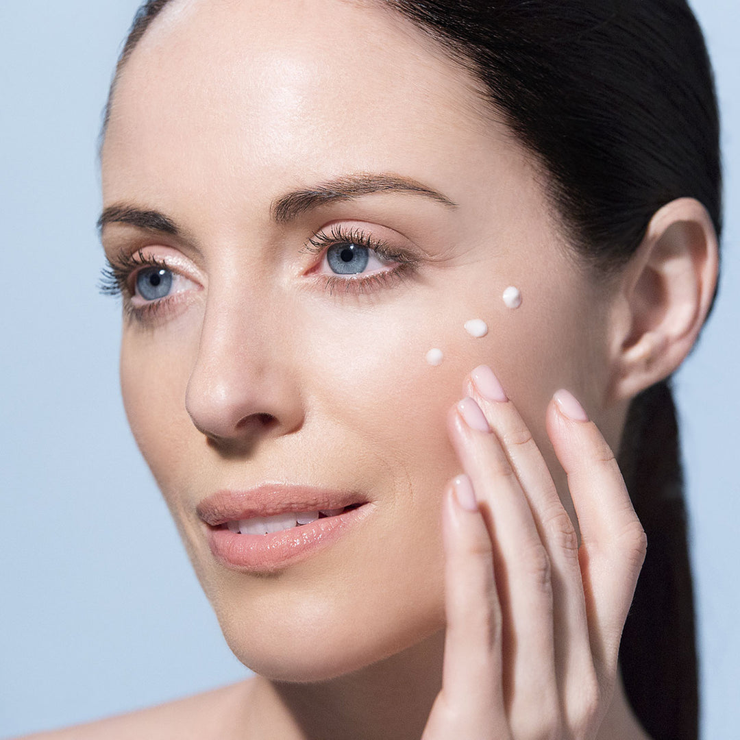 Woman applying Vita Cura® B3 Elixir Complex dots to cheek